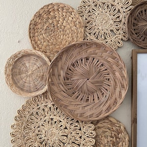 May include: A collection of woven wall decor in various shapes and sizes. The decor is made of natural materials and has a neutral colour palette.