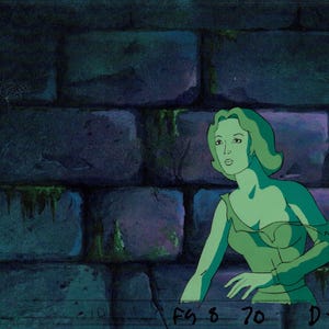 May include: Animation cel of a woman with green skin and hair, wearing a green dress, against a backdrop of a stone wall. The artwork is from a cartoon or animated film. The bottom of the image has the text "FG 8 70 D-10".