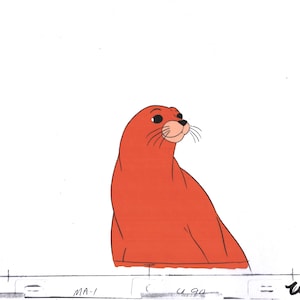 May include: A cartoon illustration of a red seal with a white face and black eyes looking to the right.