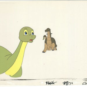 May include: A green and yellow dinosaur looks at a brown dinosaur with a green leaf in its mouth. The dinosaurs are on a white background.