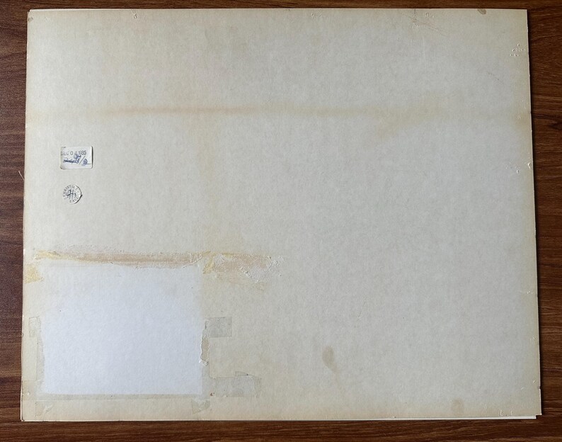 Puede incluir: Un soporte de papel rectangular de color blanco roto con una textura lisa y envejecida. La superficie presenta una peque&ntilde;a etiqueta rectangular blanca con texto impreso, un sello circular y un gran parche cuadrado blanco fijado con cinta adhesiva.