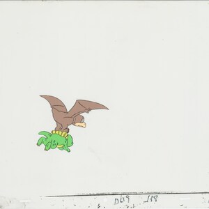 May include: A brown and green cartoon illustration of a pterodactyl flying while riding on the back of a green turtle.