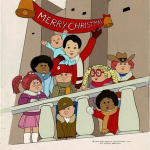 May include: A group of cartoon characters, including a baby, a boy, and several girls, are standing on a balcony. They are all wearing winter clothes and smiling. The banner above them reads "Merry Christmas".