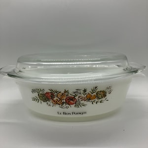 May include: White casserole dish with a clear glass lid. The dish features a decorative floral and vegetable design in orange, green, and yellow. The text "Le Bon Potager" is printed on the front.