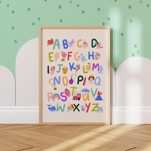 May include: A framed alphabet poster with colorful illustrations. Each letter of the alphabet is represented with a corresponding image, such as an apple for A, a cake for C, and a zebra for Z. The poster is in a light wood frame and is displayed against a light green wall.