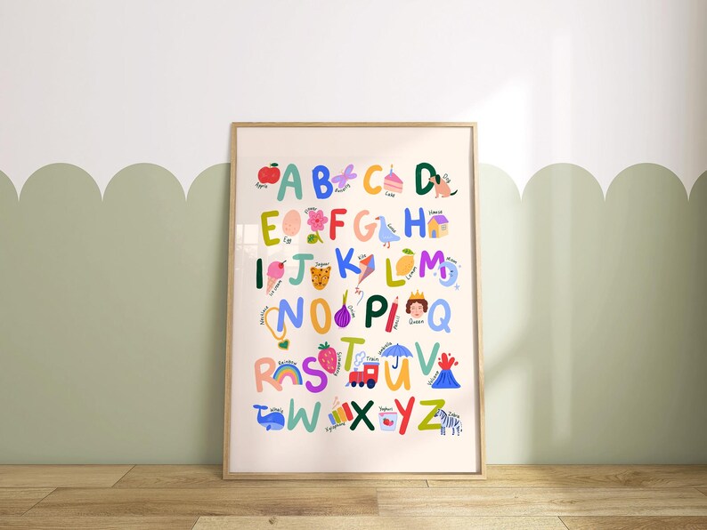 May include: A framed alphabet poster with colorful illustrations. Each letter is paired with a corresponding image, such as an apple for A, a cake for C, and a zebra for Z. The poster is in a wooden frame and is displayed on a wall.