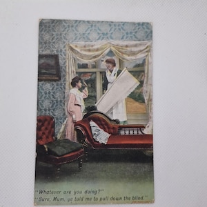 Peut inclure: Carte postale ancienne avec une illustration humoristique de deux femmes. L'une tient un store, l'autre semble surprise. Le texte dit : « Que faites-vous ? » et « Bien sûr, maman, tu m'as dit de baisser le store. »