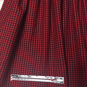 May include: Red and black gingham fabric with a white ruler measuring 3 1/2 inches.