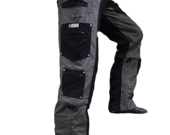 May include: Gray and black cargo pants with multiple pockets and a black label that says "VIRGO". The pants have a zipper detail on the side and are worn with black shoes.