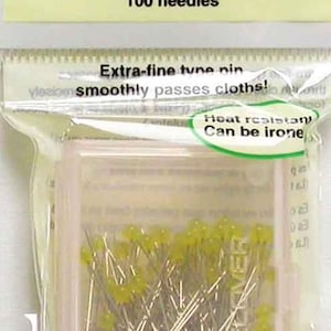 May include: A package of patchwork pins with yellow heads, 0.4mm thick and 36mm long. The package contains 100 needles. The text on the package says "Extra-fine tune pin smoothly passes cloths!" and "Heat resistant, Can be ironed".