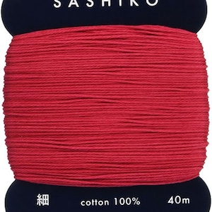 May include: A spool of red cotton thread labeled "Sashiko" with the text "cotton 100%" and "40m" on the label. The spool is made in Japan.