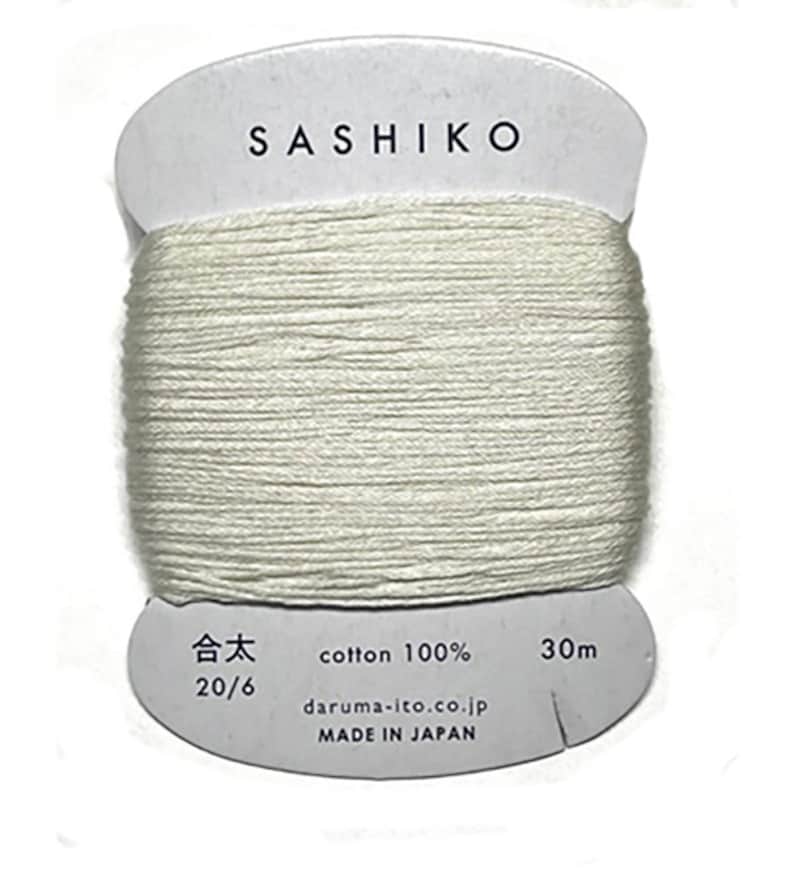 May include: A spool of white cotton thread labeled "SASHIKO" with the text "cotton 100%", "20/6", "30m", "daruma-ito.co.jp", and "MADE IN JAPAN".