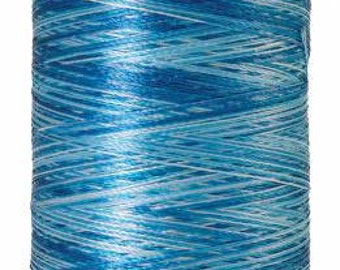 May include: A spool of Mettler brand thread in shades of blue. The thread is tightly wound around a white spool. The text "Mettler" is printed on the top of the spool. The bottom of the spool reads "Polyester No. 40 875 yds".