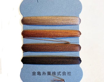 May include: A blue card with four spools of thread in shades of brown, from light tan to dark brown. The card has Japanese text at the bottom.