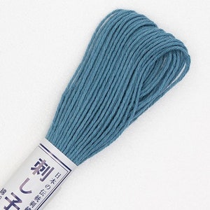 May include: A skein of light blue embroidery floss. The floss is wound around a white cardboard spool with a blue and white label that reads "刺しゅう糸" in Japanese characters.