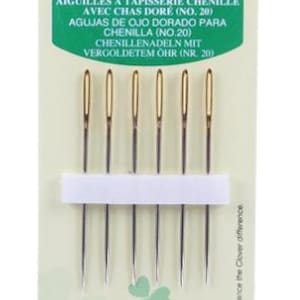May include: A package of six Clover Gold Eye Chenille Needles, size No. 20, Art No. 234/20. The needles are silver with gold-colored eyes, held in place by two white strips on a light green card with clover leaf patterns and text.