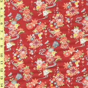 May include: Red fabric with a repeating pattern of stylized floral arrangements, fans, and geometric shapes. The design includes flowers in shades of red, yellow, blue, and white, with flowing lines and decorative elements. The fabric is measured with a ruler in inches.