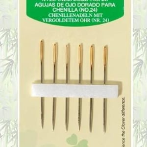 May include: A package of six Clover Gold Eye Chenille needles, size No. 24, displayed on a light beige card with green branding. The needles feature metallic gold-colored eyes and are held in place by a white foam strip. The text reads Art No. 234/24.