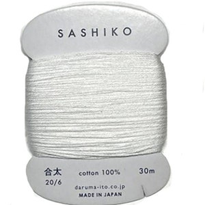 May include: White cotton thread spool labeled "Sashiko" with the text "cotton 100% 30m 合太 20/6 daruma-ito.co.jp MADE IN JAPAN"