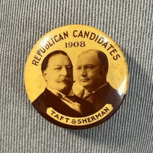 May include: A vintage political campaign button from 1908 featuring portraits of Taft and Sherman. The button has a yellow background with the words "Republican Candidates" and the year "1908" in black text. The bottom of the button reads "Taft & Sherman".