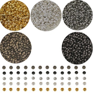 May include: Assortment of round metal beads in gold, silver, bronze, and black colors. The beads are arranged in four groups, with each group containing a different color. The beads are small and have a smooth, shiny finish.