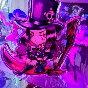 Könnte beinhalten: Ein lila und schwarzer Anime-Charakter mit langen dunklen Haaren, der einen schwarzen Zylinder mit einem Totenkopfdesign, ein schwarz-weißes Outfit trägt und eine Sense hält. Der Charakter sitzt auf einem Halbmond.