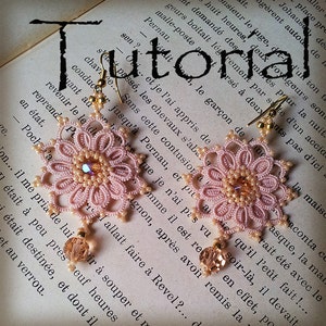 Pode incluir: Um par de delicados brincos de croch&ecirc; rosa com detalhes dourados. Os brincos t&ecirc;m a forma de flores com um pequeno cristal no centro de cada flor. Os brincos est&atilde;o pendurados em um livro com a palavra "Tutorial" escrita nele.