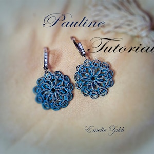 May include: A pair of blue and silver earrings with a delicate, intricate design. The earrings are shaped like a flower and have a small, clear crystal in the center. The earrings are hanging from a silver hook.