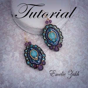 May include: A pair of teal, purple, and gold beaded earrings with a teardrop shape. The earrings are on a white surface with the text "Tutorial" and "Emelie Zakk" written in cursive.