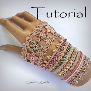 Könnte beinhalten: Ein gehäkeltes Armband mit Blumenmuster und Perlen in Rosa-, Grün- und Brauntönen. Das Armband befindet sich an einer Mannequinhand. Der Text "Tutorial" befindet sich oben im Bild.