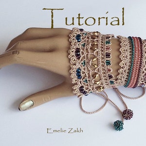 Pu&ograve; includere: Un set di quattro braccialetti all'uncinetto con perline e nappine. I braccialetti sono in tonalit&agrave; di marrone, verde e blu. I braccialetti sono legati insieme da un lungo cordoncino e hanno nappine all'estremit&agrave;. I braccialetti sono su una mano di manichino.