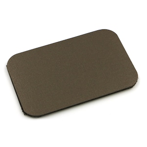 May include: A rectangular, brown leather patch with rounded corners. The patch has a textured surface and a dark brown border. The item is isolated on a white background.