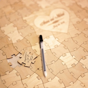May include: A wooden heart-shaped puzzle with a pen and a piece of the puzzle that says "Congratulations! We love you!"