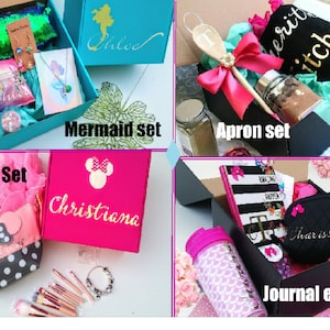 May include: Four gift boxes with different themes. The first box is turquoise blue with a mermaid design and the text "Chloe" on the lid. The second box is black with a pink ribbon and the text "Apron Set". The third box is pink with a Minnie Mouse design and the text "Christiana". The fourth box is black with a black and white striped journal and the text "Journal etc."