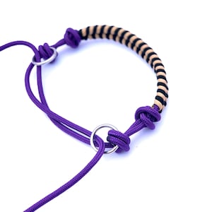 Op de afbeelding: Paarse touwhalster met een bruin en zwart gestreept touw accent en twee zilveren metalen ringen.