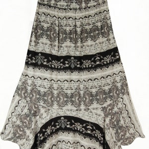 May include: A long, flowing skirt with a black and white geometric pattern. The skirt has a slightly asymmetrical hemline and a comfortable elastic waistband.