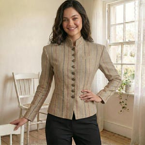 May include: A beige blazer with vertical stripes in red and blue. The blazer has a mandarin collar, a row of brown buttons, and a small pocket on the chest. The person is wearing black trousers.