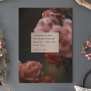 May include: A quote by Elsie de Wolfe printed on a brown background with a blurred image of pink roses in the background. The quote reads: "I am going to make everything around me beautiful - that will be my life."
