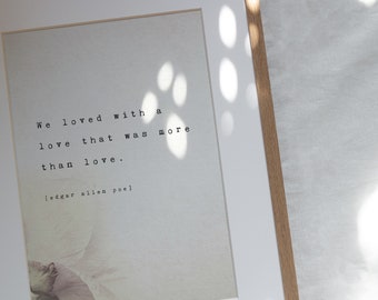 May include: A framed print with a white background and black text that reads "We loved with a love that was more than love. [edgar allen poe]"