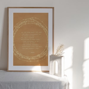 May include: A framed print with a beige background and gold glitter stars forming a circle around a quote by Rumi. The quote reads: "Do you know what you are? You are a manuscript of a divine letter. You are a mirror reflecting a noble face. This universe is not outside of you. Look inside yourself. Everything that you want, you are already that."