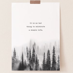 May include: Black and white print featuring a quote that reads "It is no bad thing to celebrate a simple life." The quote is centred on a white background with a misty forest scene below.