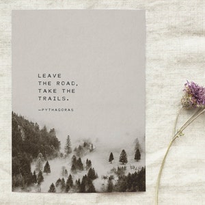 May include: A black and white photo of a misty forest with the quote "Leave the road, take the trails." attributed to Pythagoras.