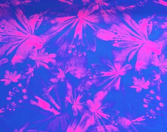 May include: A blue fabric with a pink floral pattern. The flowers are abstract and have a watercolor effect.