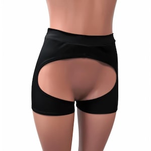 May include: Black shorts with a cut-out detail in the back. The shorts are made of a stretchy fabric and have a high waist.
