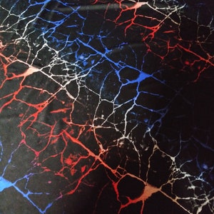 May include: Black fabric with a red, white, and blue marble pattern. The pattern resembles cracks in a surface.
