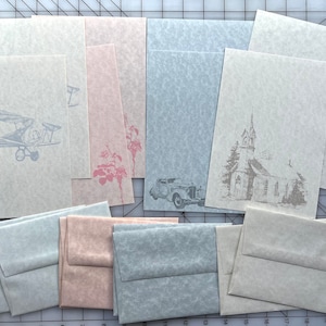 May include: A set of stationery paper and envelopes in three colors: light blue, pink, and white. Each sheet features a different design: an airplane, a car, and a church.