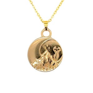 Puede incluir: Un collar de oro con un colgante redondo que presenta una luna creciente, una cordillera y una silueta de ciervo. El colgante está detallado con estrellas y un paisaje montañoso texturizado.