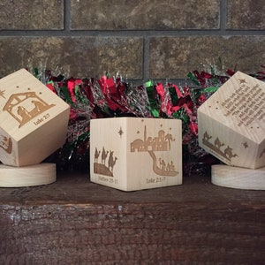 May include: Three wooden cubes with Christmas scenes and Bible verses. The first cube shows the nativity scene with the verse "Luke 2:7". The second cube shows the three wise men with the verse "Matthew 2:9-11" and "Luke 2:1-7". The third cube shows the three wise men with the verse "All that the Father giveth me shall come to me; and him that cometh to me I will in no wise cast out. For I came down from heaven, not to do mine own will, but the will of him that sent me. And this is the Father's will which hath sent me, that of all which he hath given me I should lose nothing, but should raise it up again at the last day. For this is the will of my Father, that every one which seeth the Son, and believeth on him, may have everlasting life: and I will raise him up at the last day." John 6:37-40.