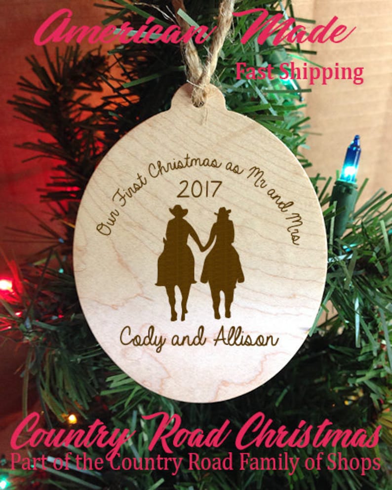 May include: A wooden Christmas ornament with the text "Our First Christmas as Mr and Mrs 2017" and "Cody and Allison". The ornament features a silhouette of a couple riding horses.