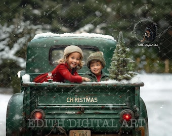 May include: Two children, a girl wearing a red sweater and a boy wearing a green sweater, sit in the back of a green vintage pickup truck decorated with the words "Christmas". The truck is covered in snow and the children are smiling.